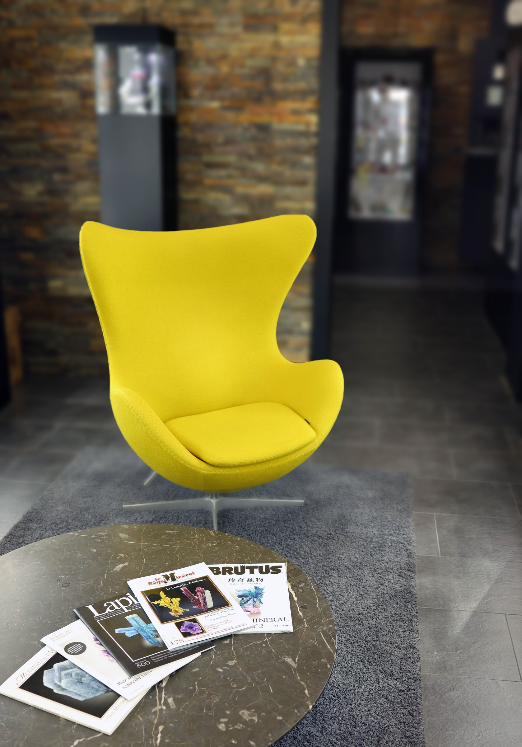 A reading corner with a yellow chair and mineral publications in the museum